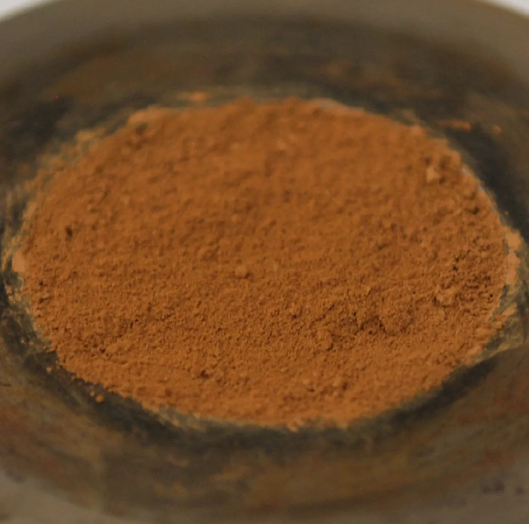 A disc of orange-terracotta coloured dust fills the frame. The dust looks quite soft and fine, more like flour than sand.