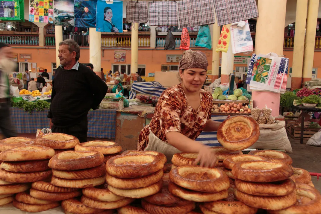 Vendor selling traditional bread at Panjshanbe Bazaar, Khujand, Tajikistan