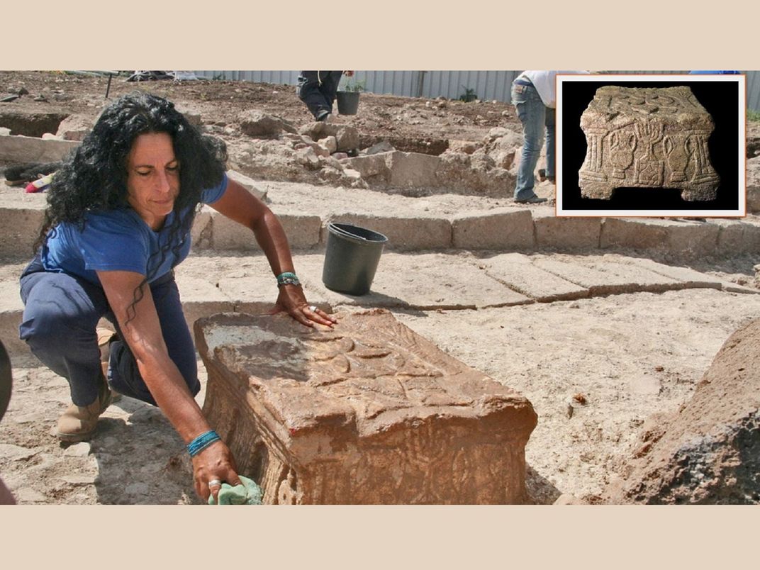 Archaeologists excavates stone with menorah design