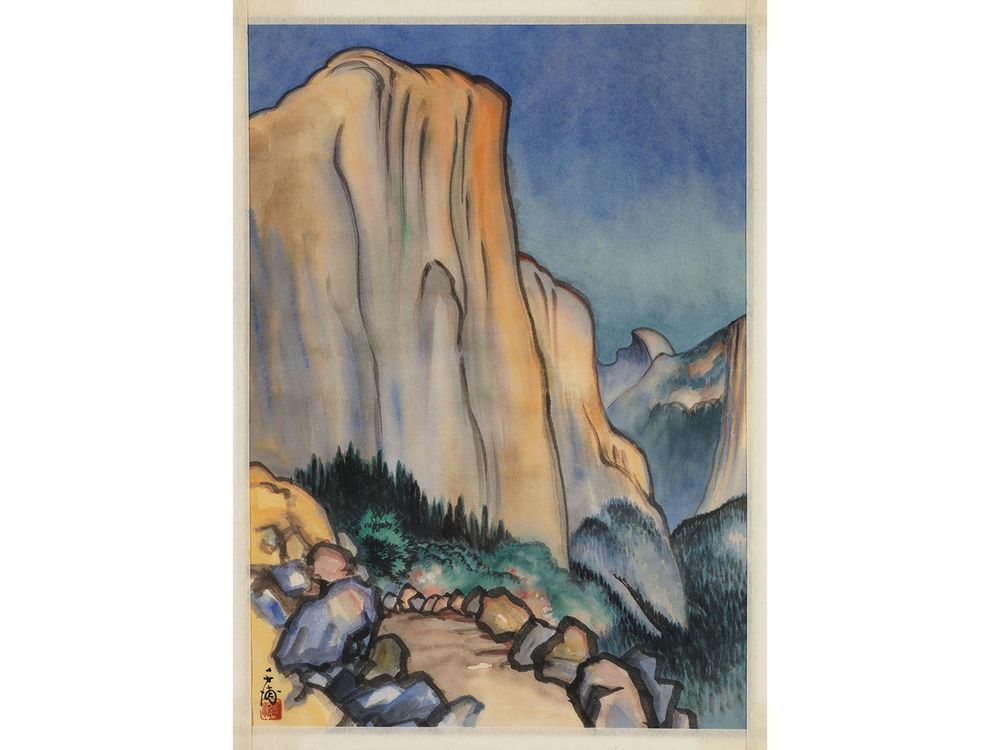 Watercolor image of mountain scene with a cloudless blue sky, trees and boulders in the foreground, and the artist’s stamp in the bottom left-hand corner.