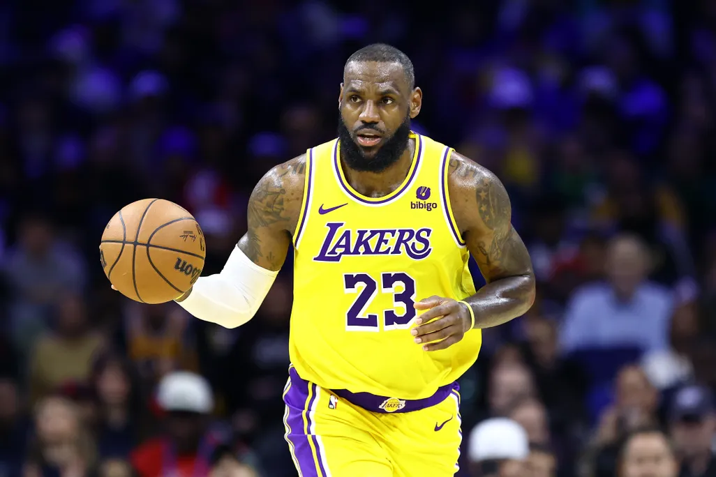 LeBron James dribbling a basketball in a yellow Lakers jersey