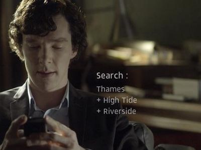 Benedict Cumberbatch as Sherlock Holmes searching for clues on his mobile phone