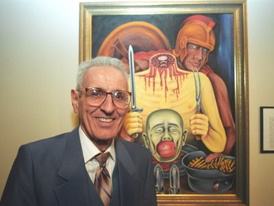 Jack Kevorkian stands in front of one of his paintings.
