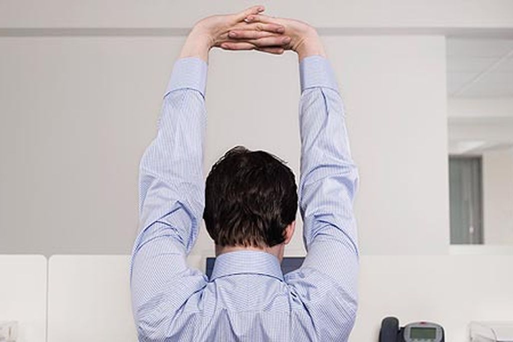 Employee in cubicle stretching