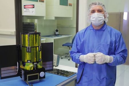 Planetary Resources president Chris Lewicki stands next to the Arkyd space telescope.