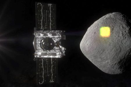 Bennu is shaped like a three-dimensional diamond and seemingly smooth from far away. OSIRIS-REx is in the foreground of this artist’s replication. The spacecraft will gather a sample from Bennu next week. (NASA/Goddard/University of Arizona)