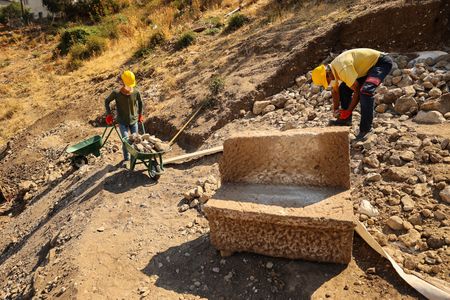 The stone seats are inscribed with Latin names in Greek letters.