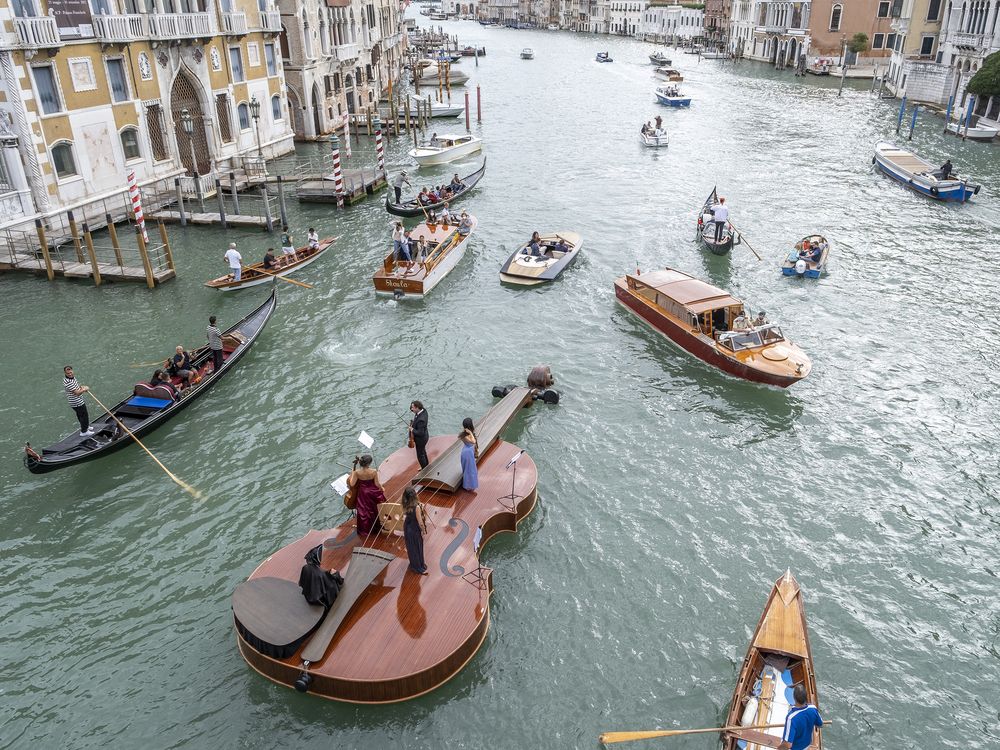 Aerial view of violin vessel sailing down Venice's Grand Canal