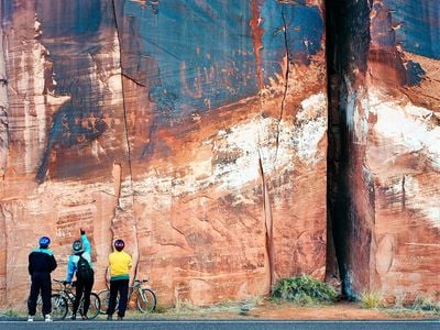 Cyclists Inspecting Ancient Petroglyphs, Utah, 1998: Texas-based photographer Terry Falke captures several of the exhibition's themes in this image of cyclists examining petroglyphs and bullet holes in a stratified rock face by the side of the road in Utah. "You’ve got the ultimate strata, which is man-made, so the idea is that we are impacting, we’re leaving our mark on the Earth over time as well," says Talasek. 