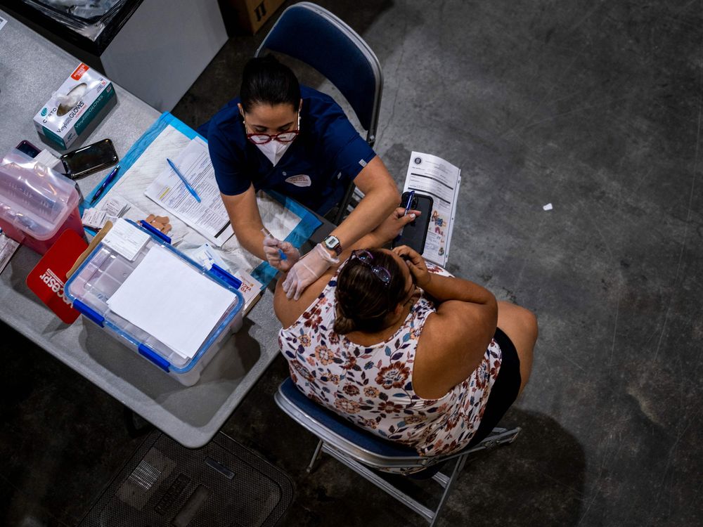 An image of a healthcare worker administering a shot at the Puerto Rico connvenction center during a vaccination event.