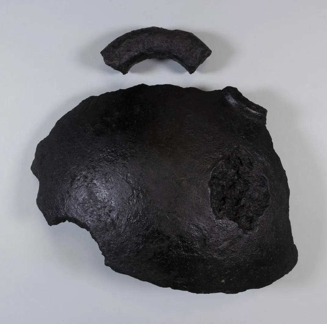 Pieces of a mortar shell against a white backdrop
