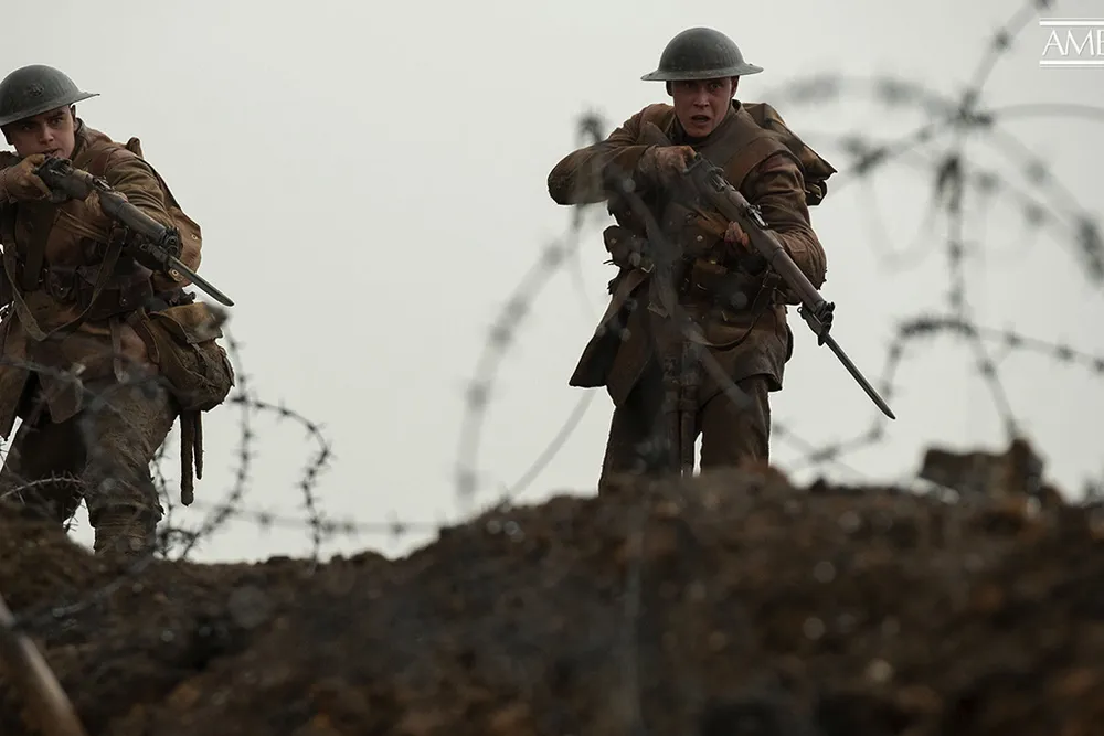 Scene from 1917 movie of two soldiers with guns 