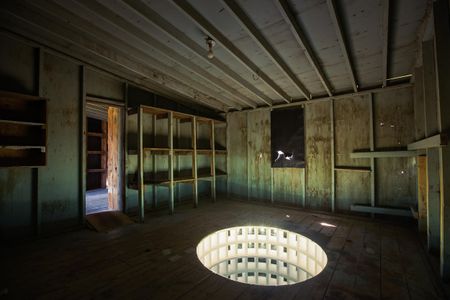 Glenn Kaino's "Hollow Earth" installation uses a trick of light to show an lit tunnel delving into the ground