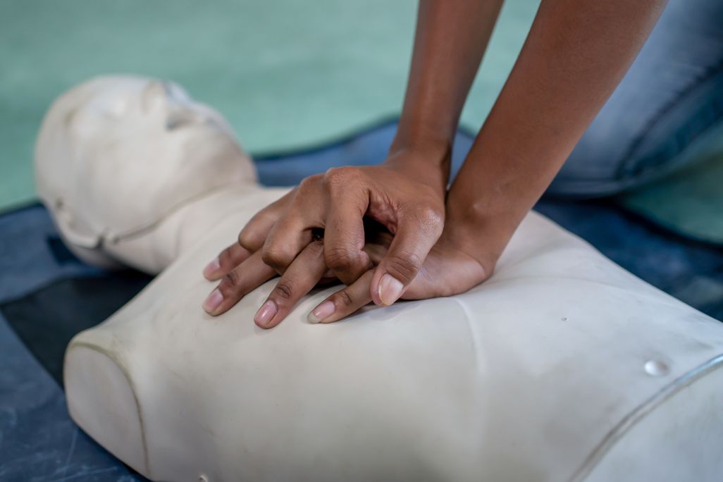 A person performs CPR on a dummy