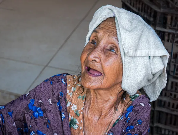 Elderly Vietnamese woman selling lottery tickets in a floating market, thumbnail