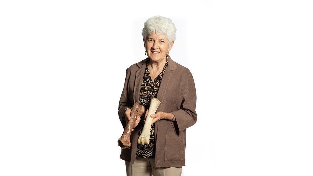 A person holding two fossil bones.