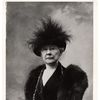 Black and white portrait of Mary Cassatt sitting in a chair wearing fur and a feathered hat.