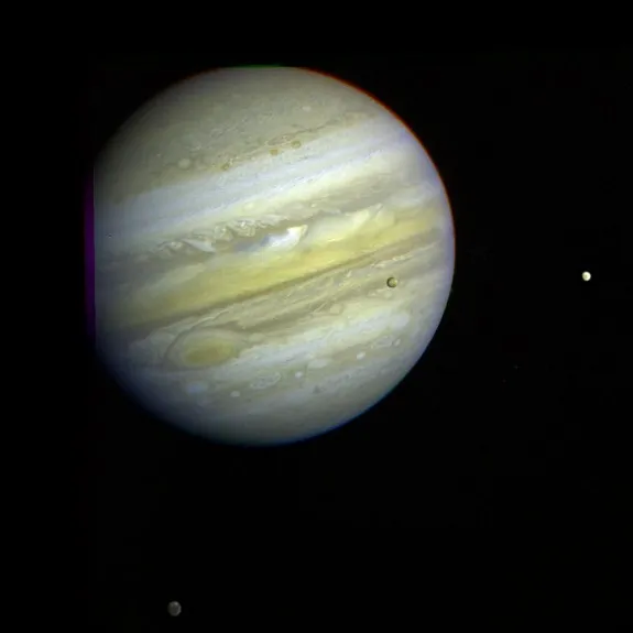 Three of Jupiter’s moons, Callisto, Io, and Europa can be seen orbiting the gas giant.