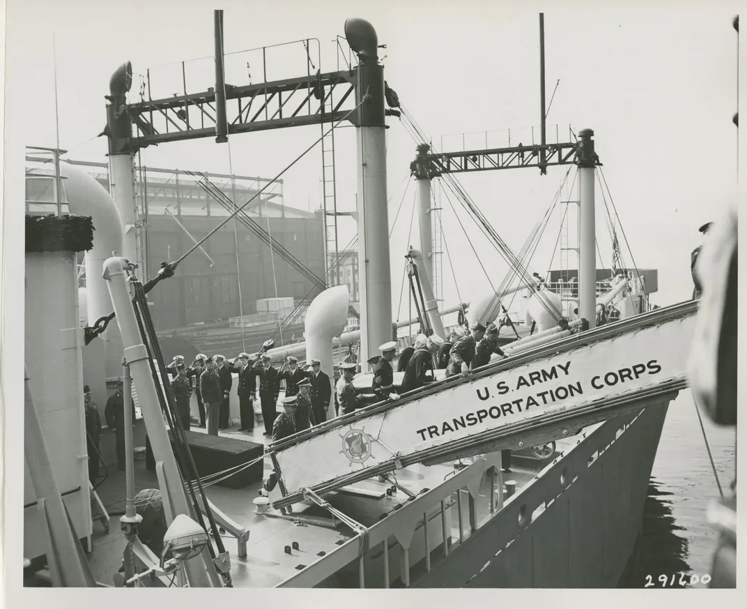 Pallbearers remove a casket containing the remains of a Medal of Honor winner from the Joseph V. Connolly.