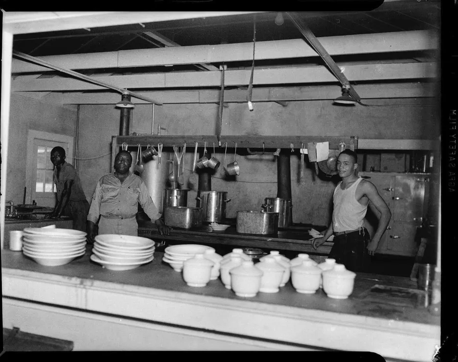 Three men in military mess kitchen