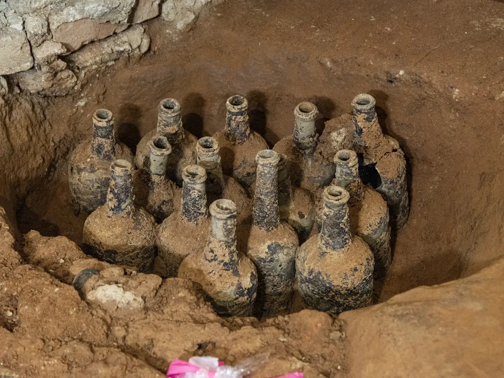 Bottles covered in dirt in a pit