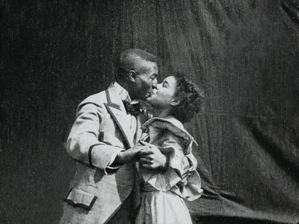 Black and white image of a black man and a black woman kissing