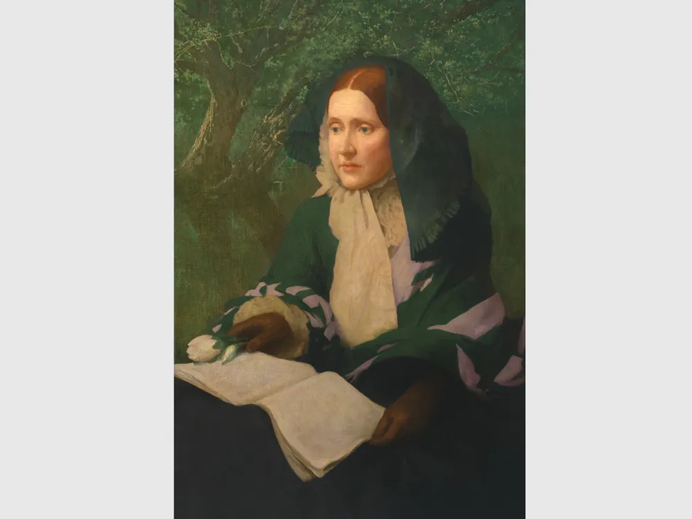 Julia Ward Howe posed seated with a book open on her lap.