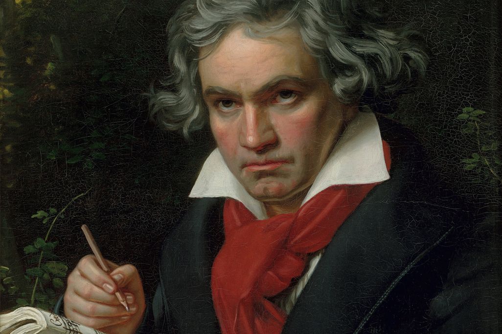 the composer beethoven wearing a black jacket and red scarf, pencil in and and a musical score in the other
