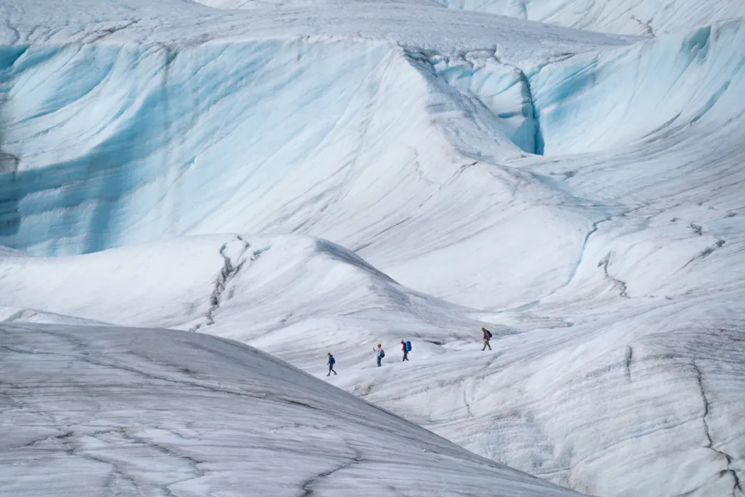 Hikers make their way across the Root Glacier in Wrangell-St. Elias National Park.