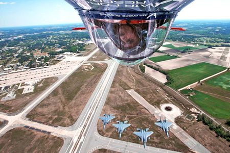 Pilot Ed Hamill turns his Air Force Reserve stunt plane upside down to get a better look at four F-15E Strike Eagles approaching from the rear.  Mr. Hamill was participating in a two-day air show on at Seymour Johnson Air Force Base, N.C., April 25 and 26 that attracted more than 100,000 spectators.  (U.S. Air Force photo)