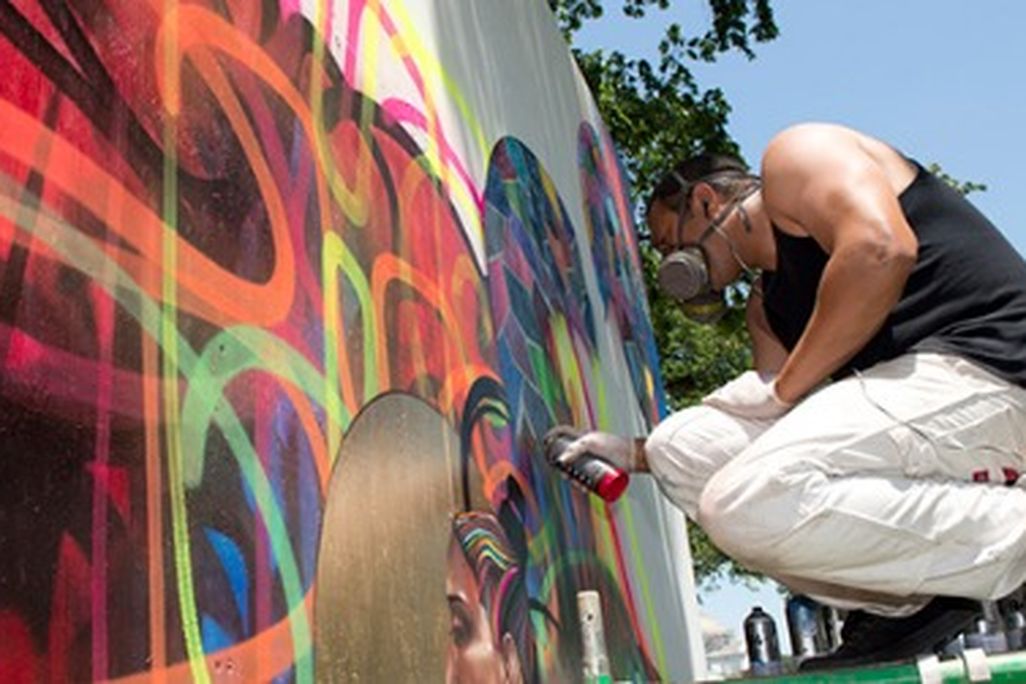 An artist works on a mural installation in the “Citified” program.