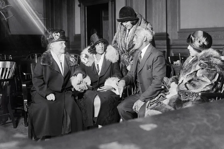 Alice Beatrice Rhinelander, née Jones (seated at center), looks at her father, George Jones, as they await the verdict in the Rhinelander v. Rhinelander ​​​​​​​case.