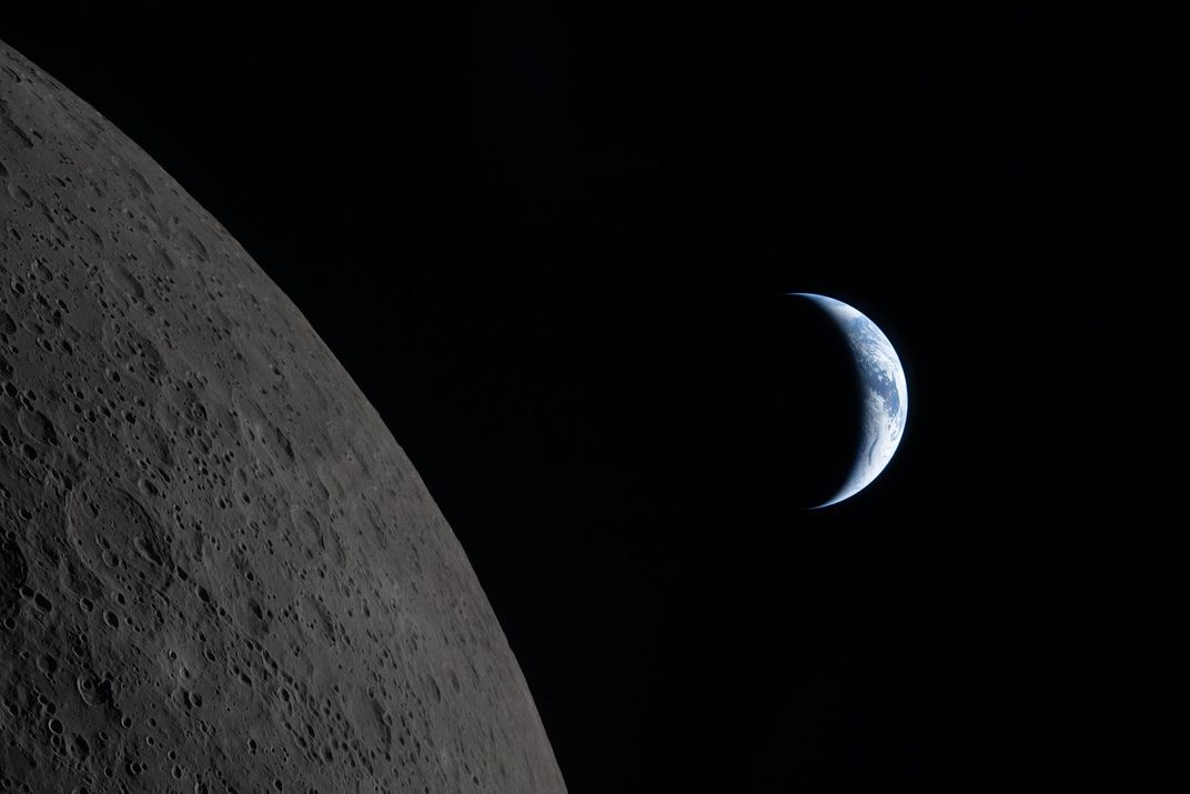 the moon in the foreground and a crescent Earth in the background