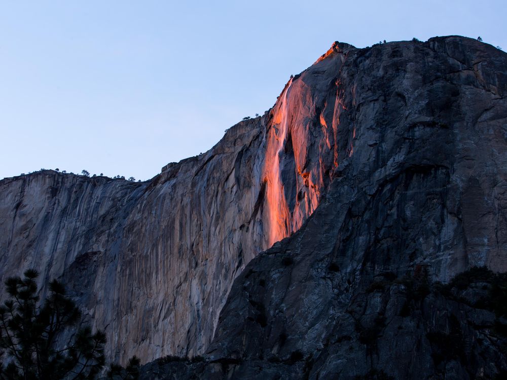 The photo shows Horsetail Falls glowing a fiery orange color. 