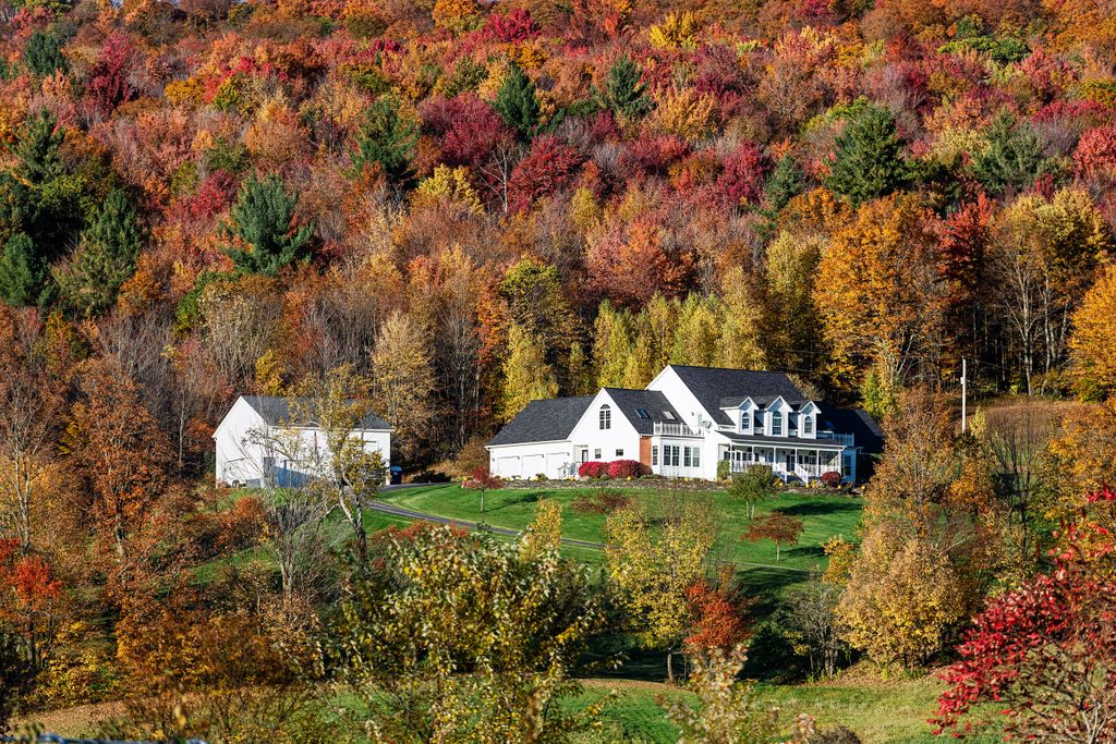 A large estate in a Vermont hillside photographed in fall foliage