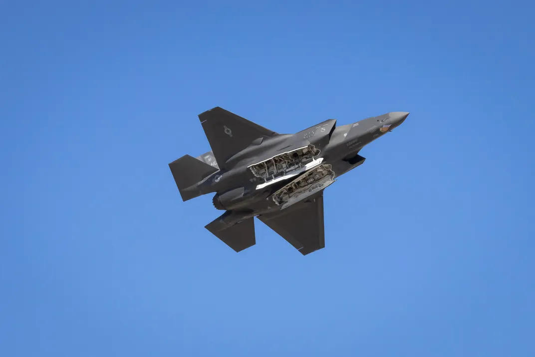 3 - At the Pikes Peak Regional Air Show, a fighter jet flies overhead with its two missile bays open.