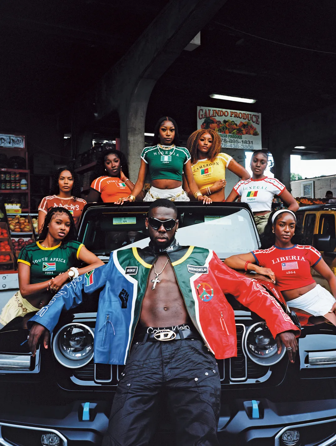 a group of people sit on a car for a portrait