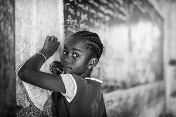 A child writing things down in a school in The Gambia thumbnail