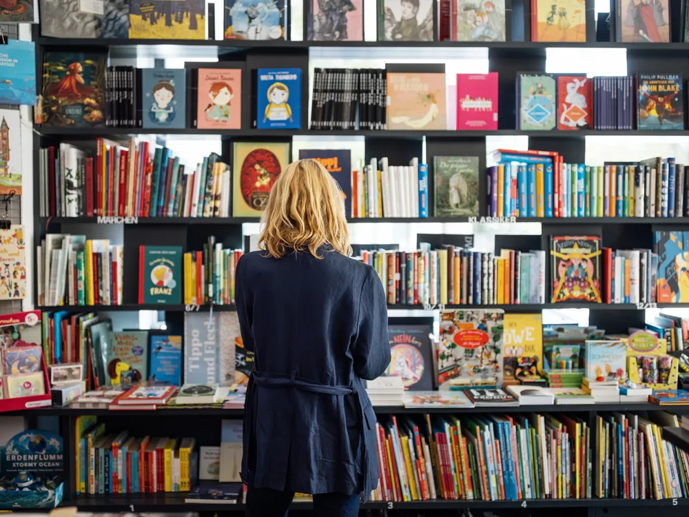 Rear view of a woman looking at books at a bookshop.