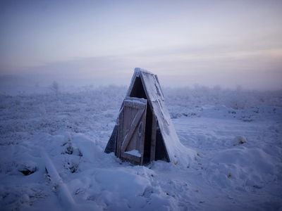 A toilet on the tundra at a gasoline stop on the road to Oymyakon. A sharp spire of frozen excrement rose almost to ground level from the pit beneath. 