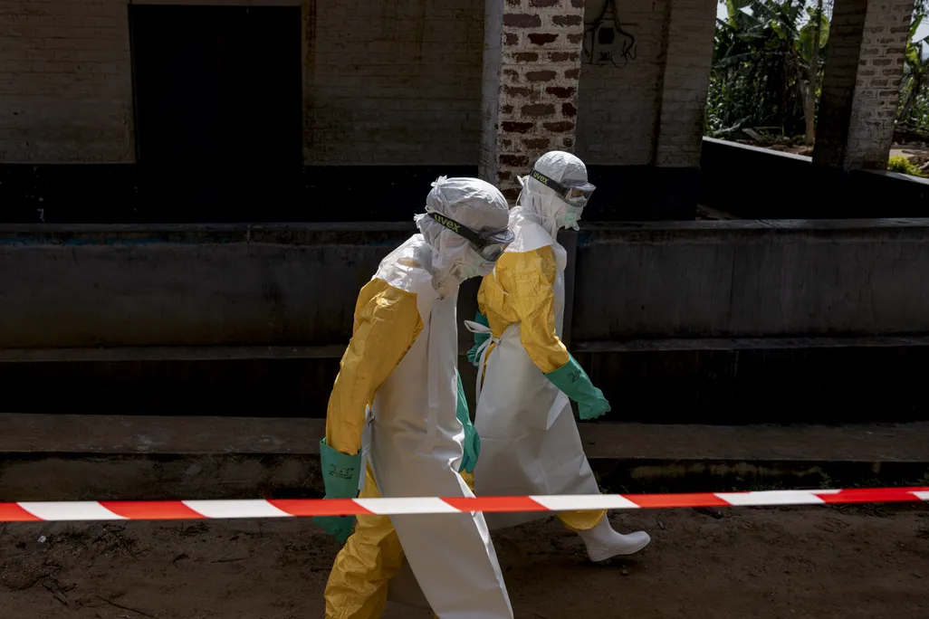 two people in full protective equipment walking on the street
