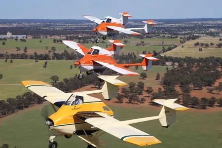 A rare three-ship formation of TransAvia PL-12 AirTruks led by Ian Bell (in yellow) with Nick Wills (center) and Steve Death (top) departs an October 2018 airshow in Temora, New South Wales, Australia. 

