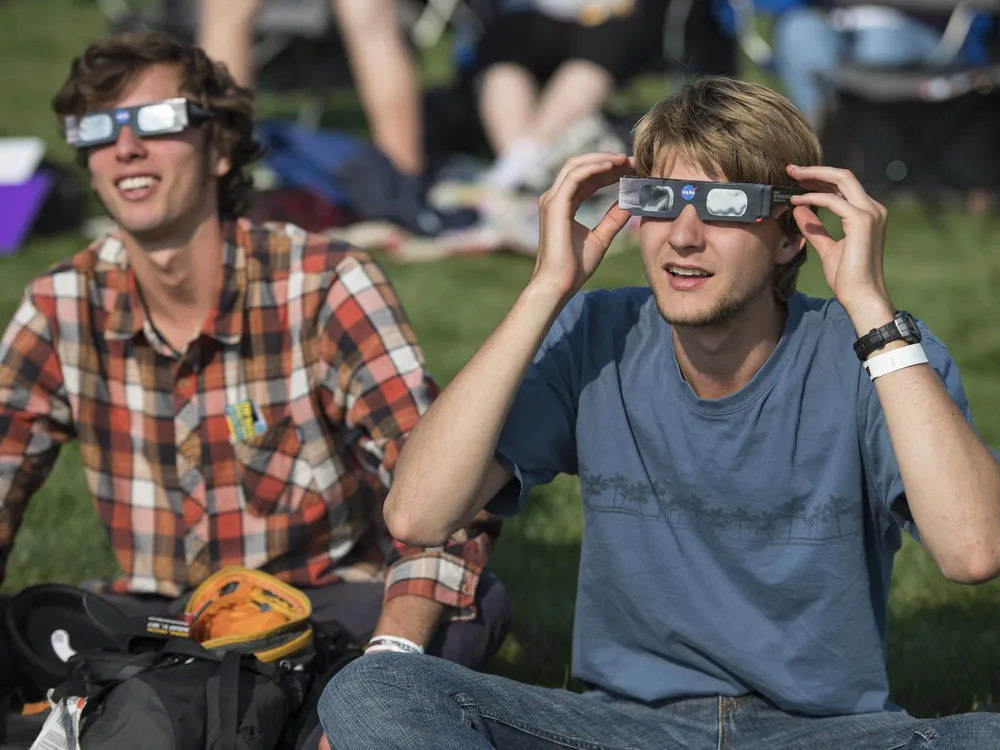 Two men wearing eclipse glasses