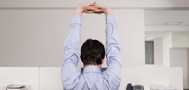 Employee in cubicle stretching