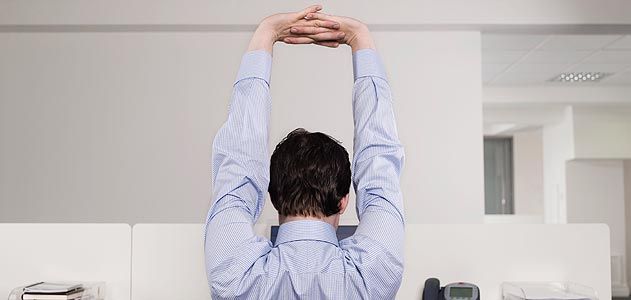 Employee in cubicle stretching