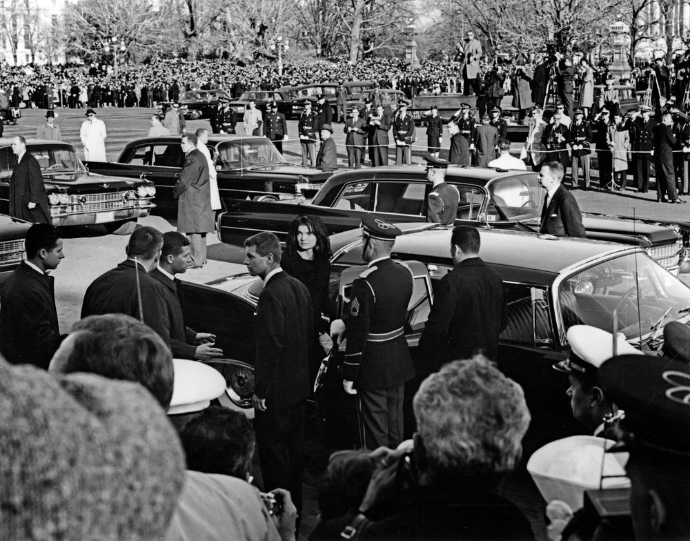 Jackie Kennedy and Attorney General Robert F. Kennedy (both standing by car) prepare to depart the U.S. Capitol following the president's funeral.