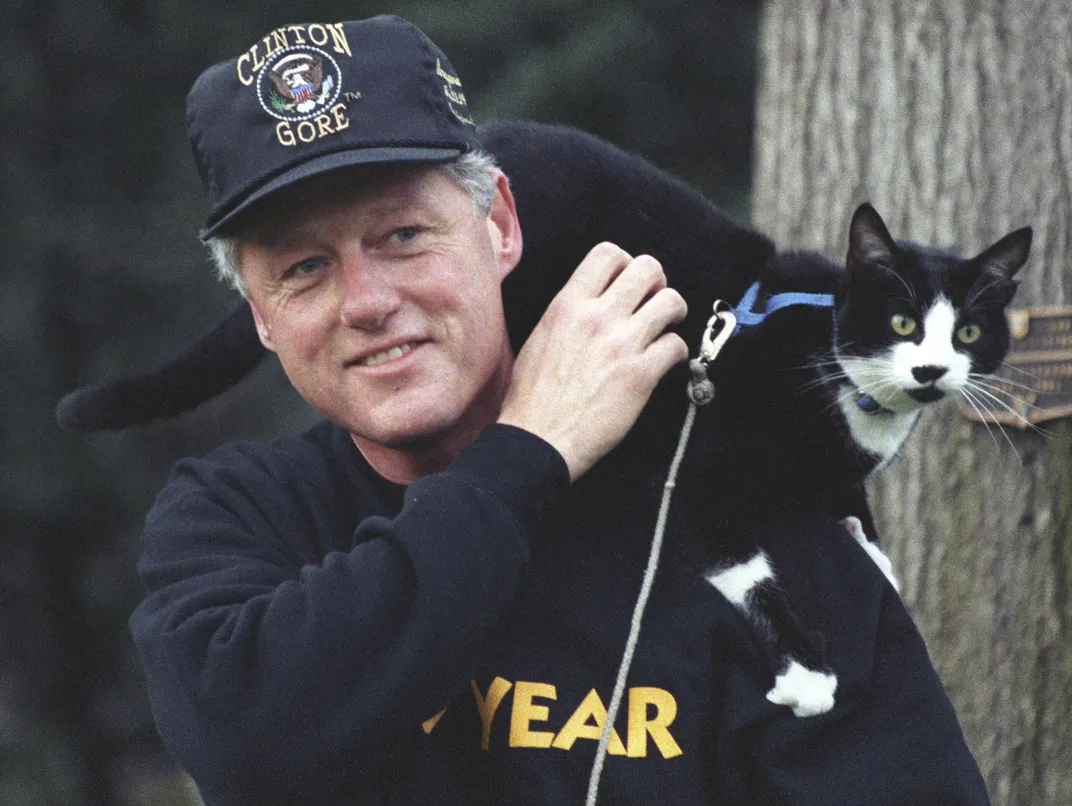 Socks the cat perches on Bill Clinton's shoulders