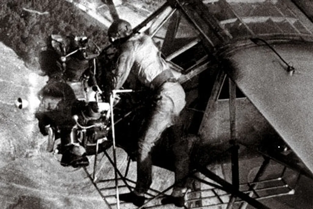 In a 1935 publicity stunt, Fred Key checks the oil in flight.