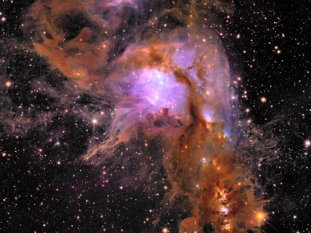 a purple and orange cloud of gas with bright dots of stars all over