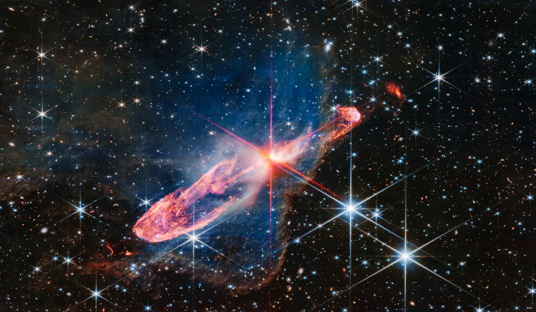 two young stars merging in a cloud of blue and red with several stars and galaxies surrounding them